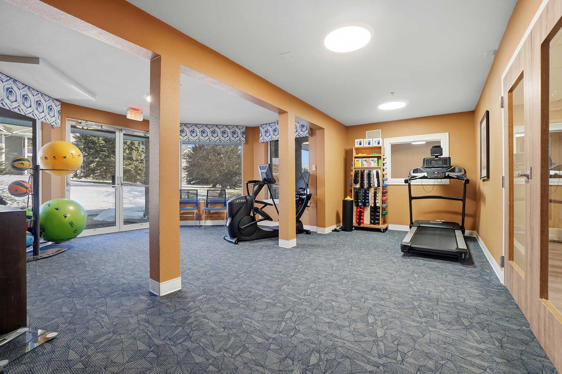 Fitness center at Mallard Point Senior Living, featuring treadmill, elliptical, exercise balls and other items, renovation completed in 2025.