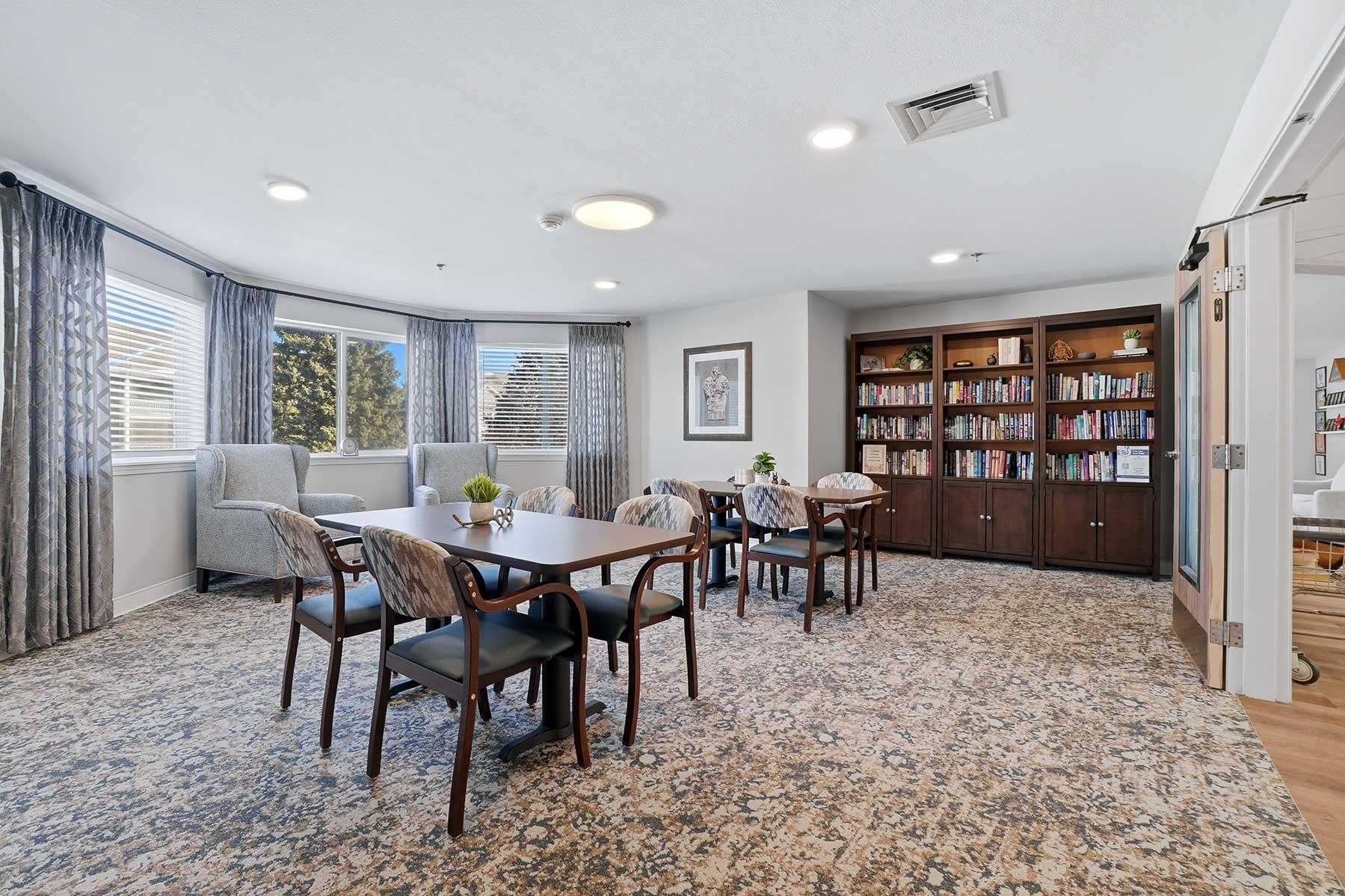Common space featuring dark wood book shelves and inviting seating at Mallard Point Senior Living, renovation completed in 2025.