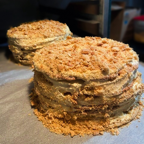 Two many-layered cakes with frosting and crumb coating. 